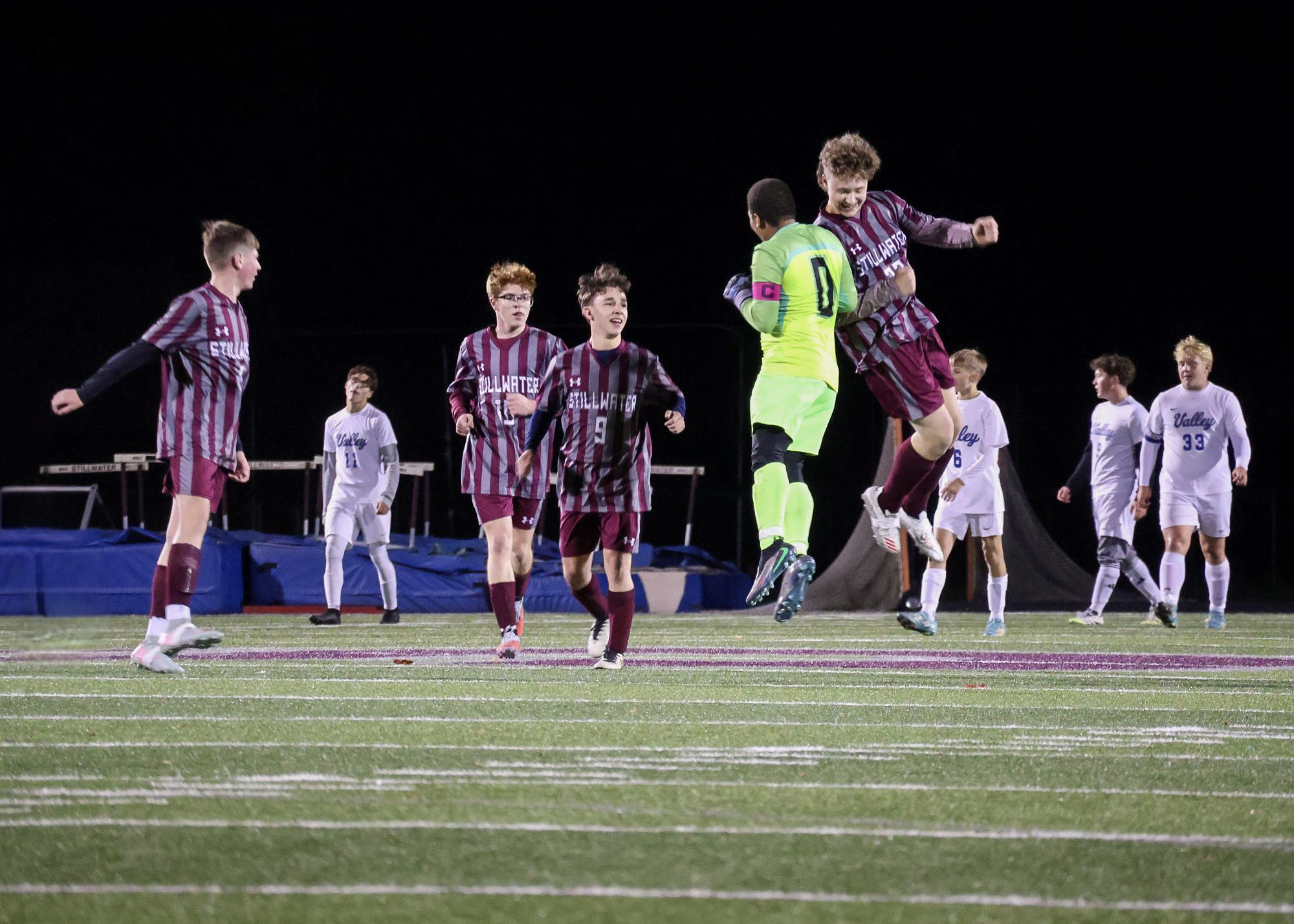 students sitting with their awards from a sports event