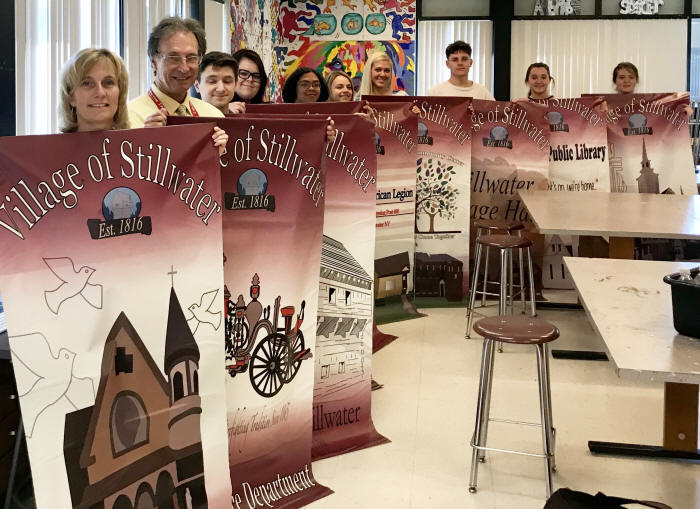 Stillwater art students pose with the banners they made for the village