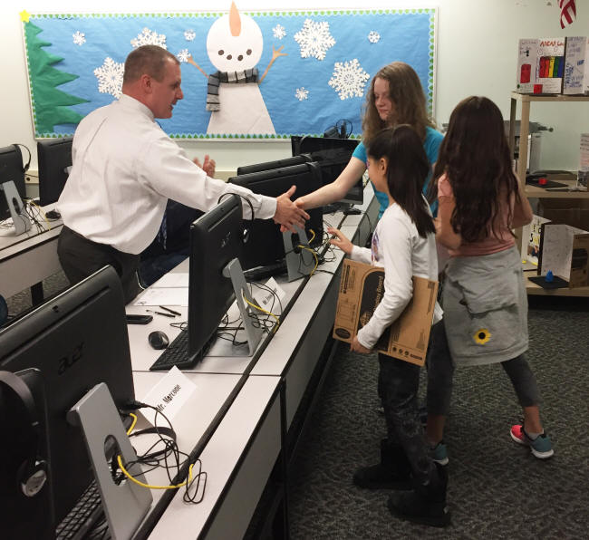 A team of students shakes hands with Mr. Froschauer after a "Shark Tank" presentation