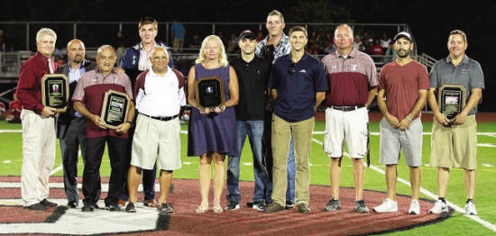 Inductees lined up in a row on the football field