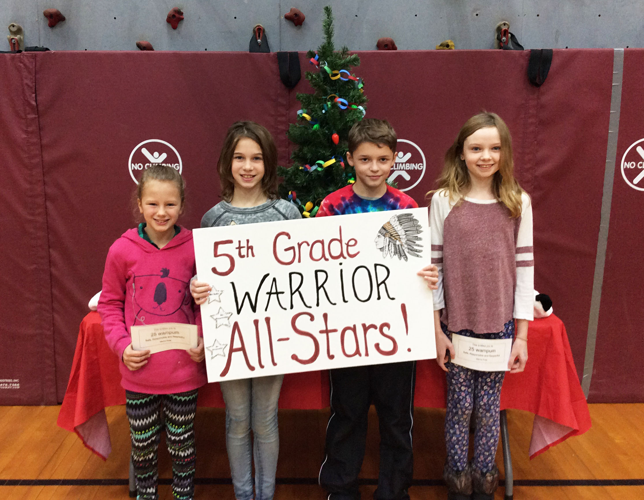 Students grouped together with a sign showing their grade level.