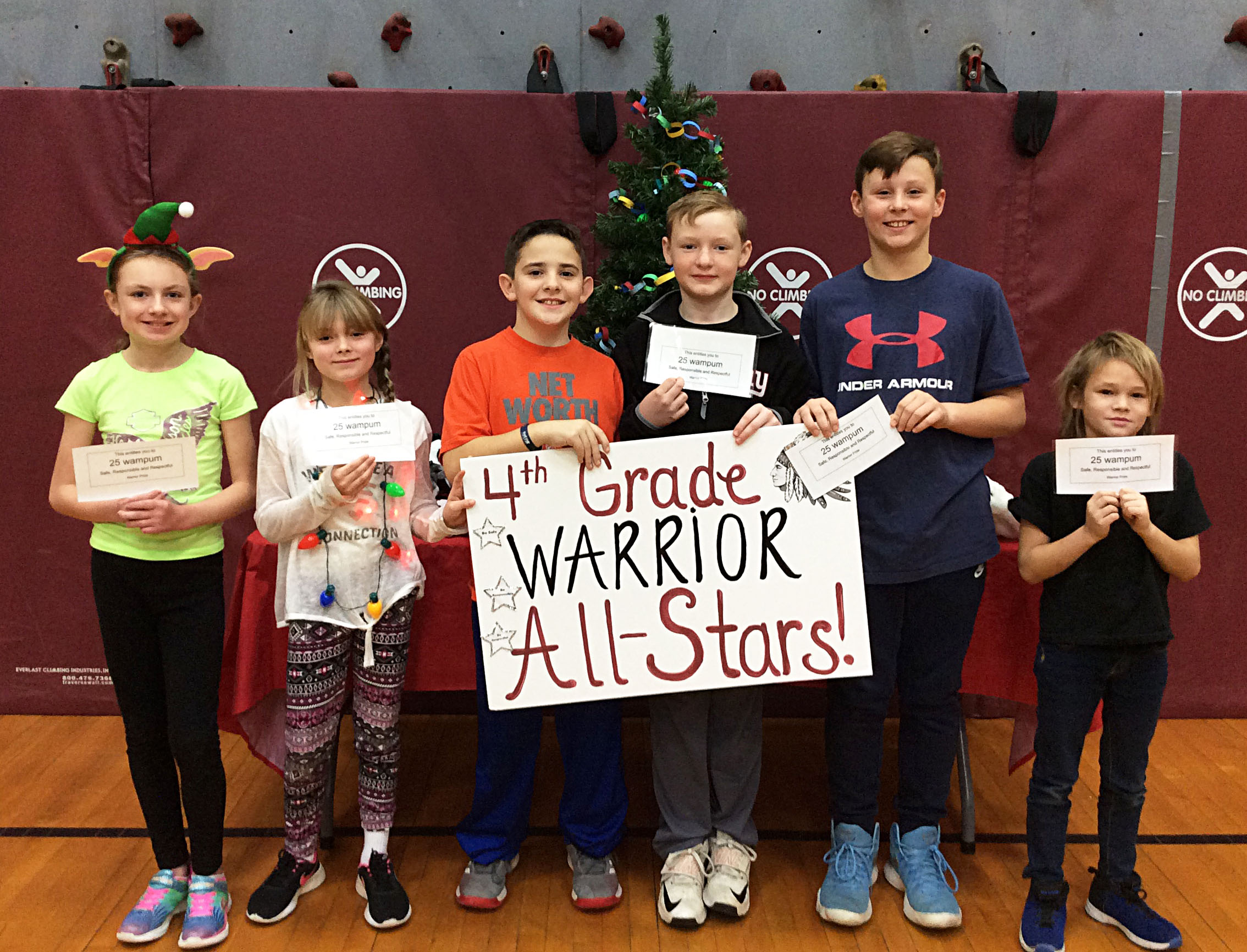 Students grouped together with a sign showing their grade level.