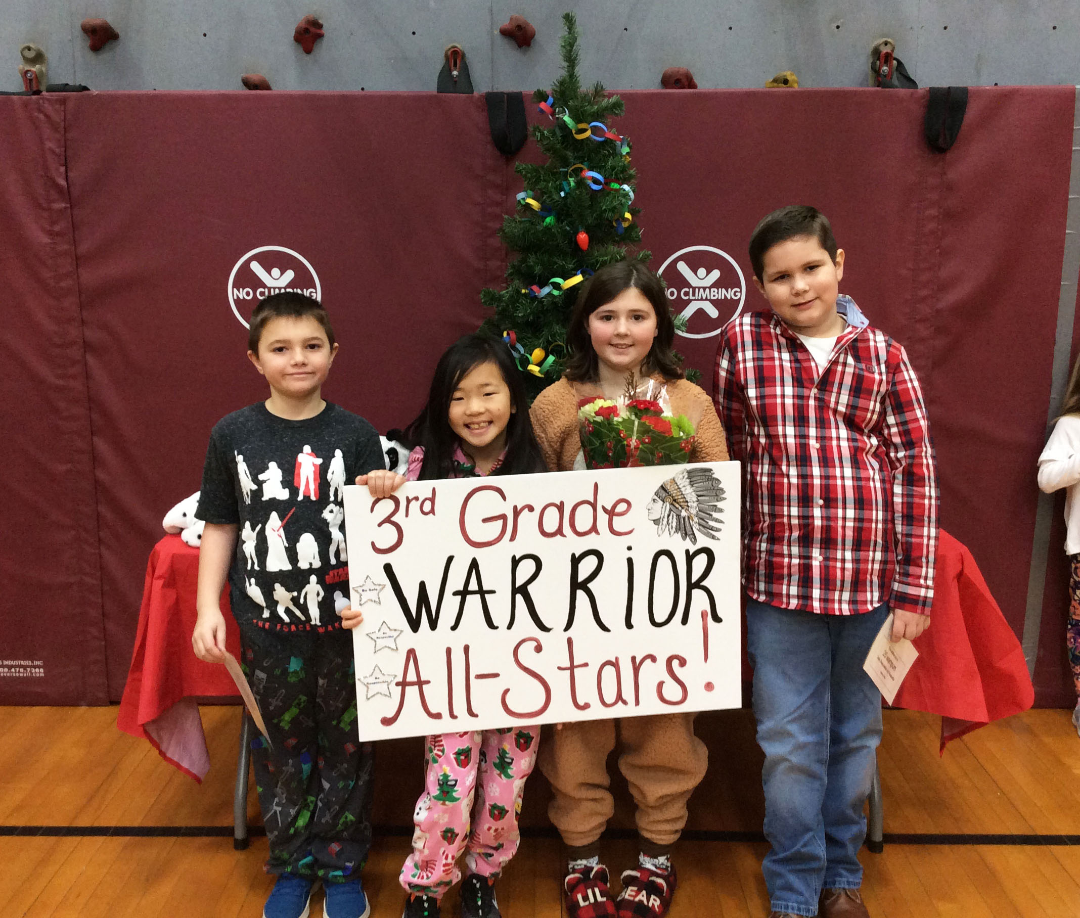 Students grouped together with a sign showing their grade level.