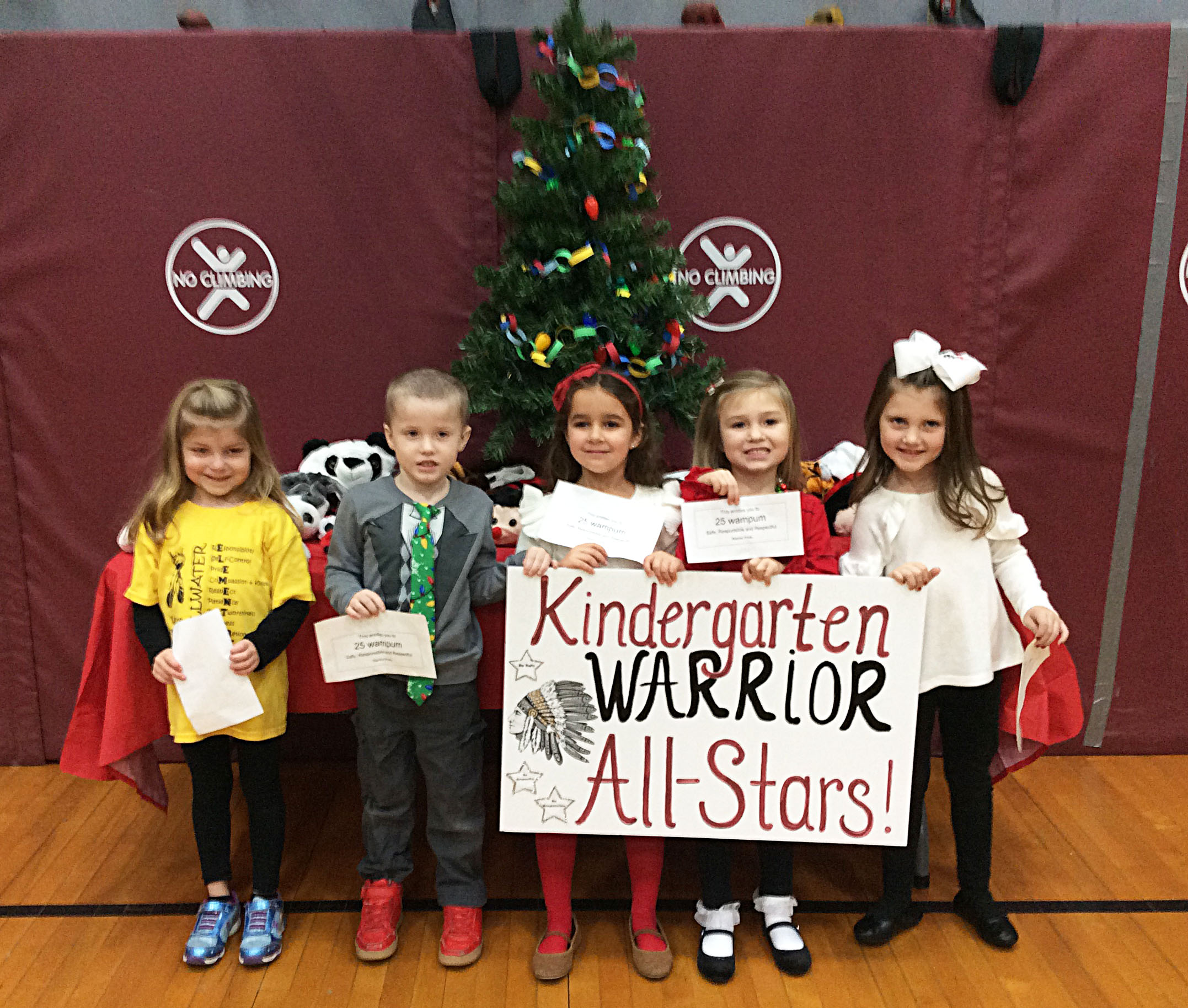 Students grouped together with a sign showing their grade level.