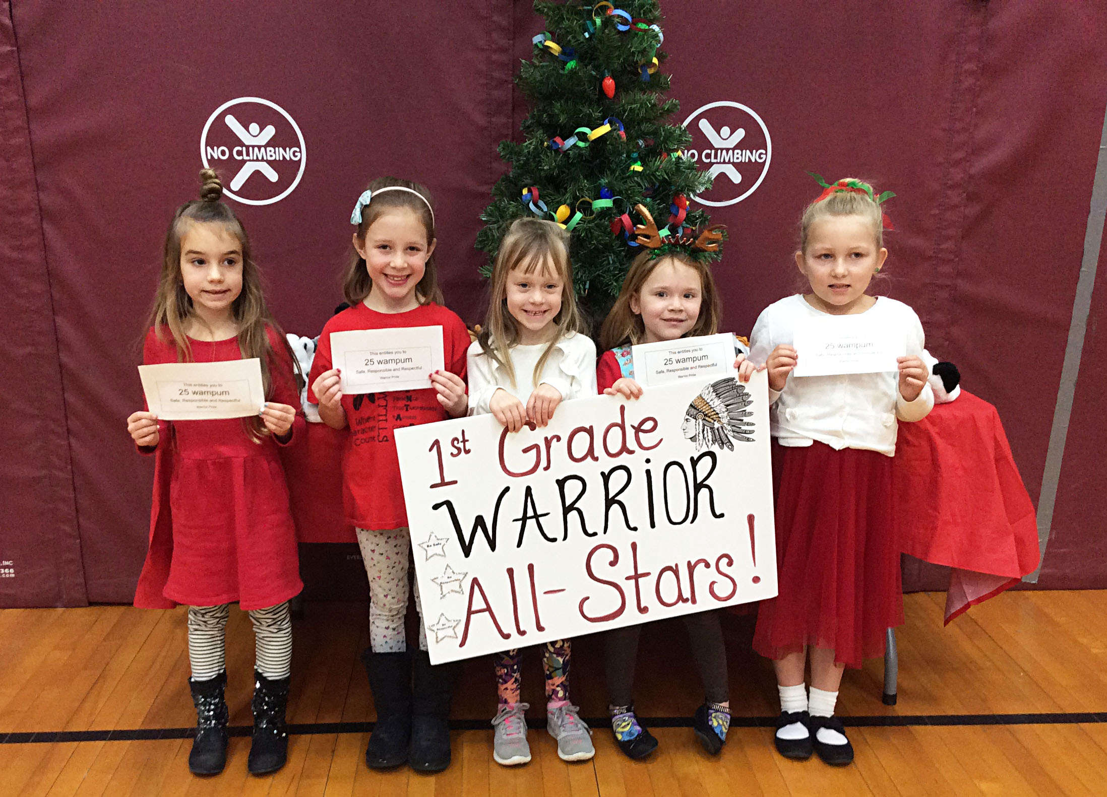 Students grouped together with a sign showing their grade level.