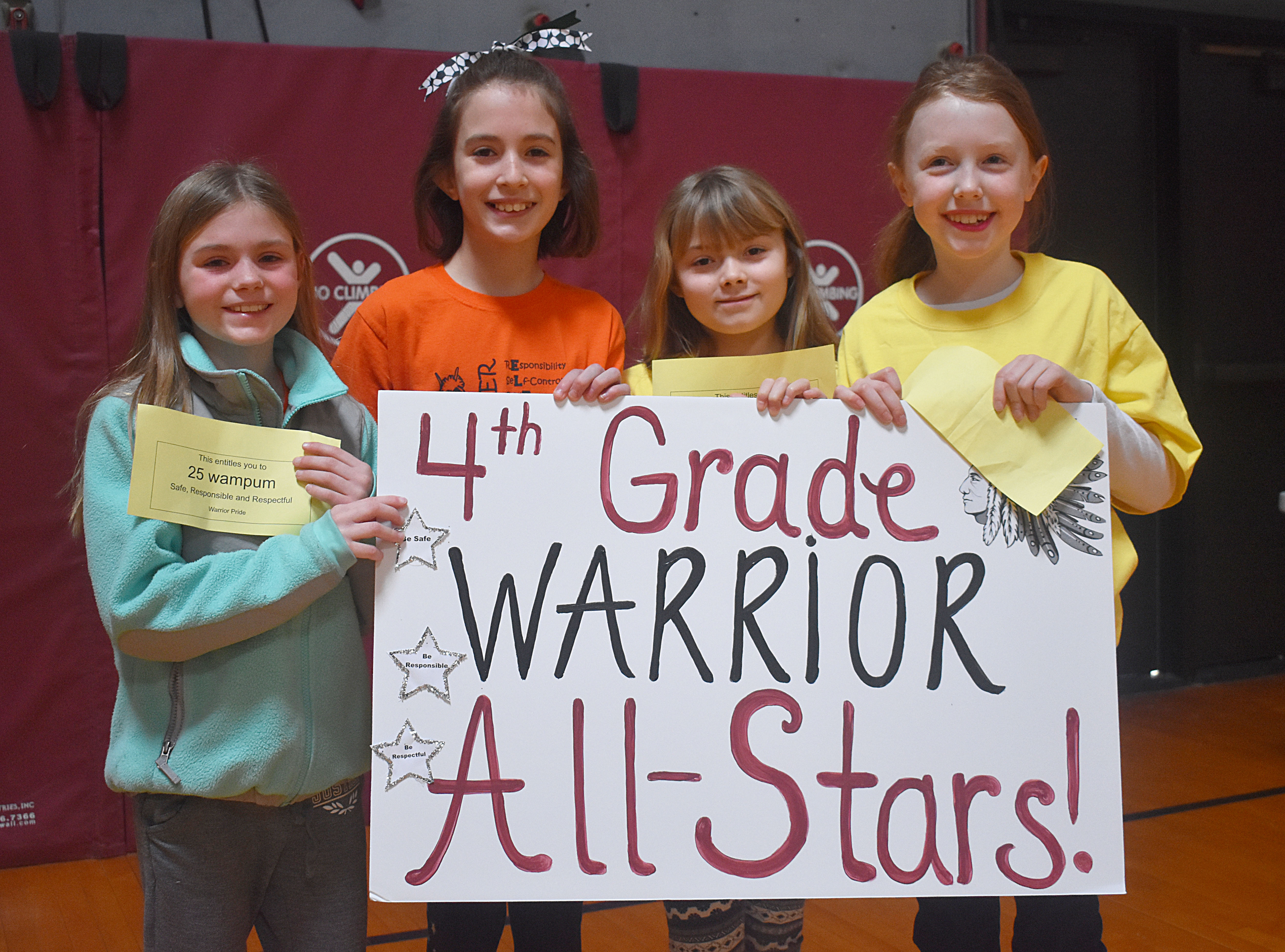 Students grouped together holding their grade level sign