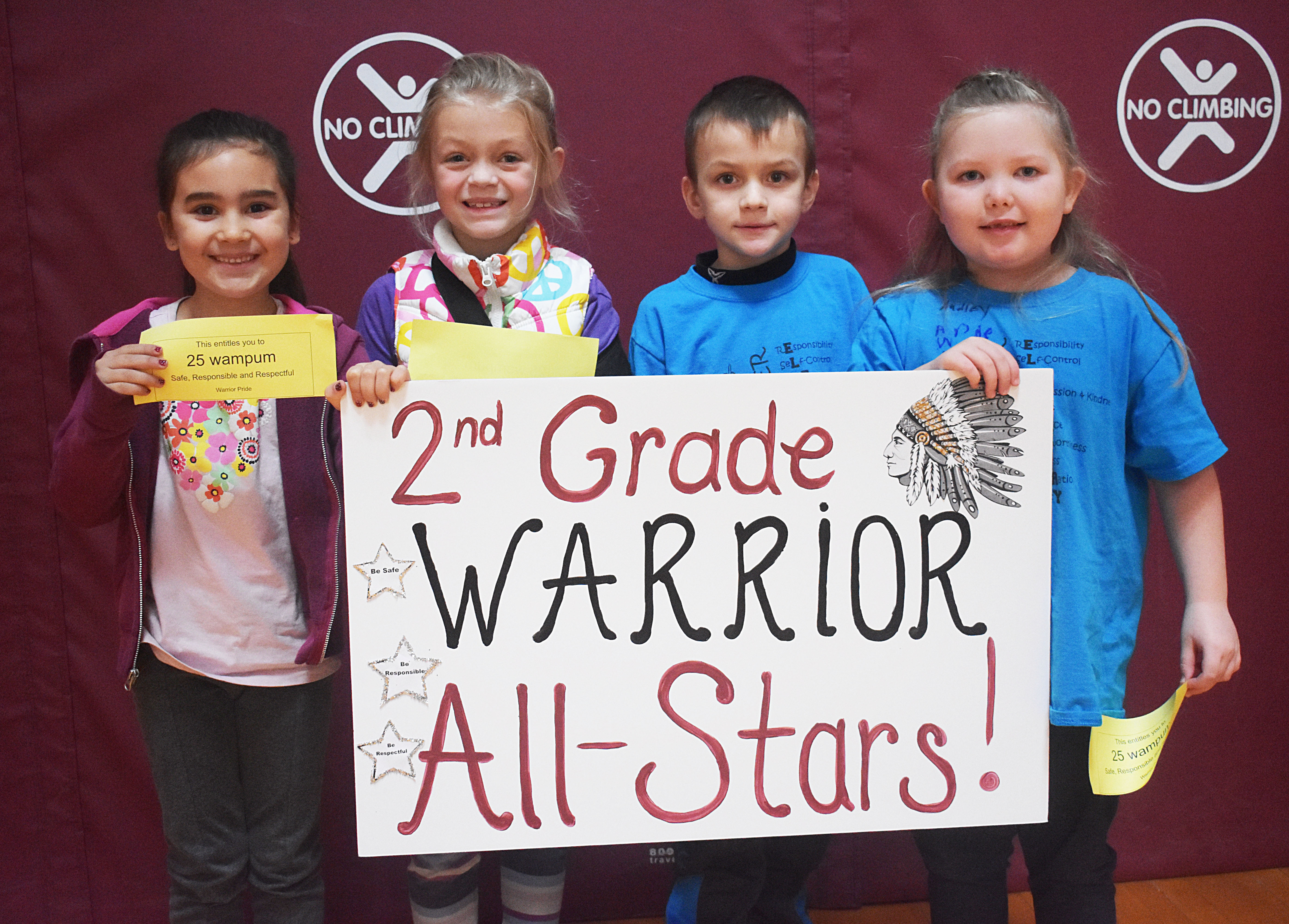 Students grouped together holding their grade level sign