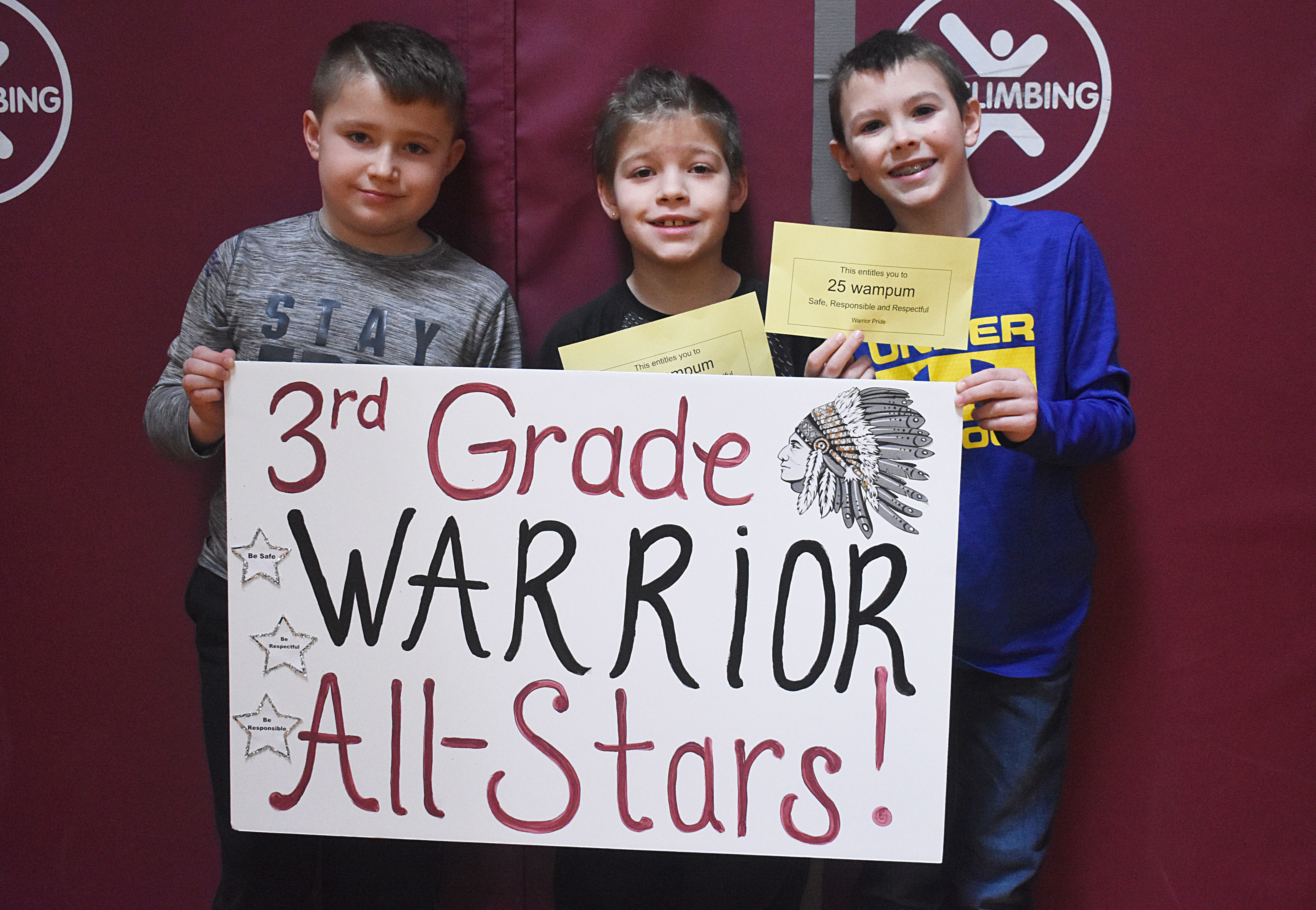 Students grouped together for a photo with their grade level sign