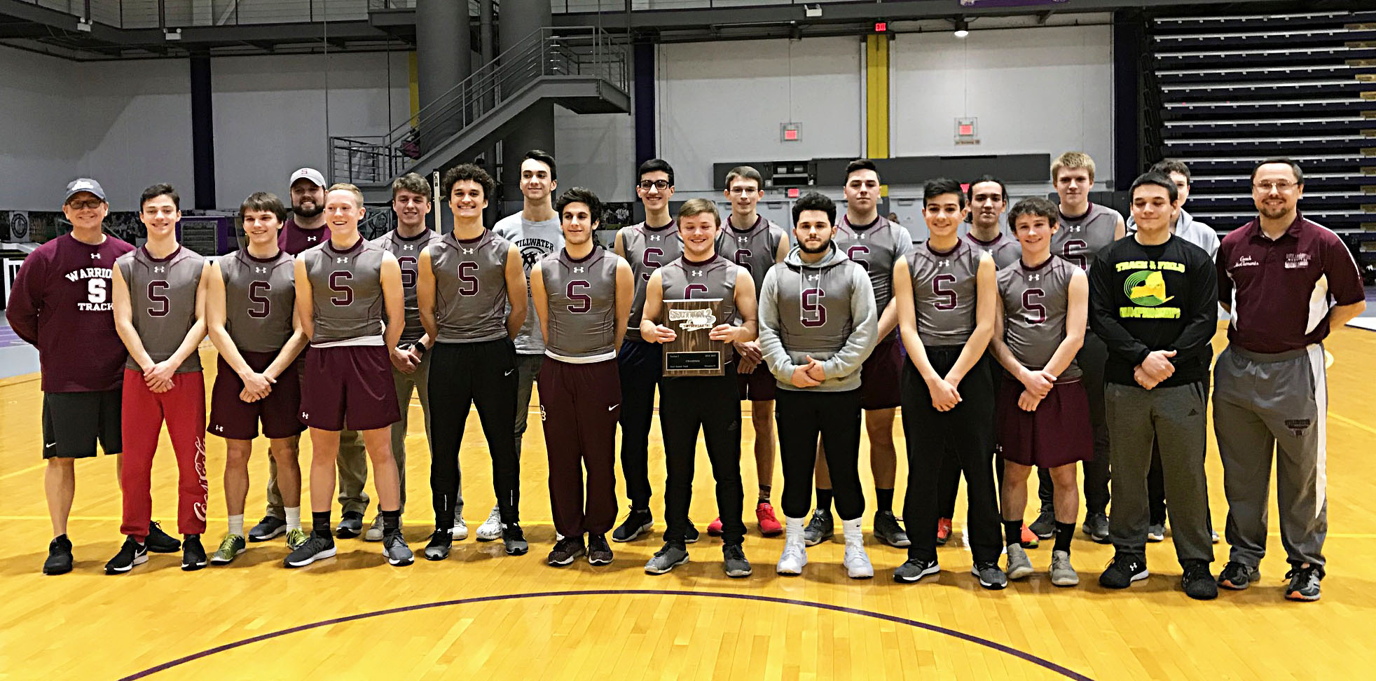 Boys team gathered together posing with trophy