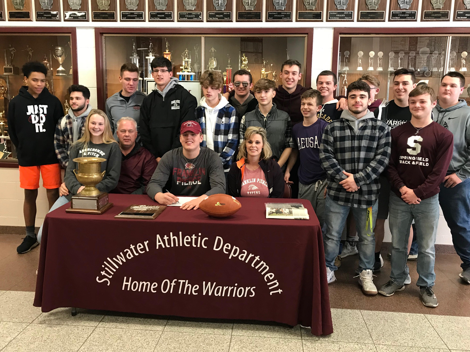 Students and family gathered with athlete at a table