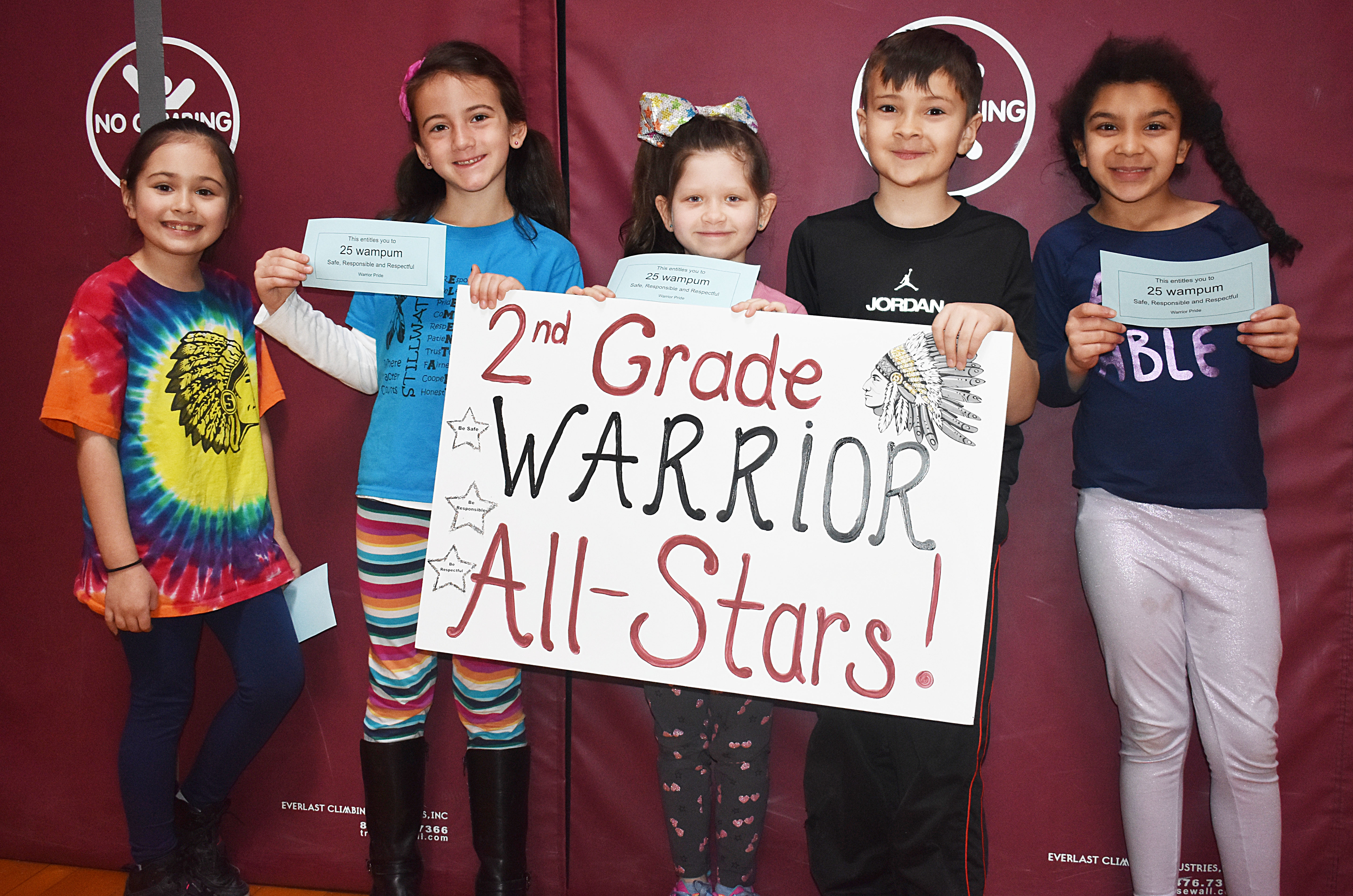 A group of students standing together with a second grade sign