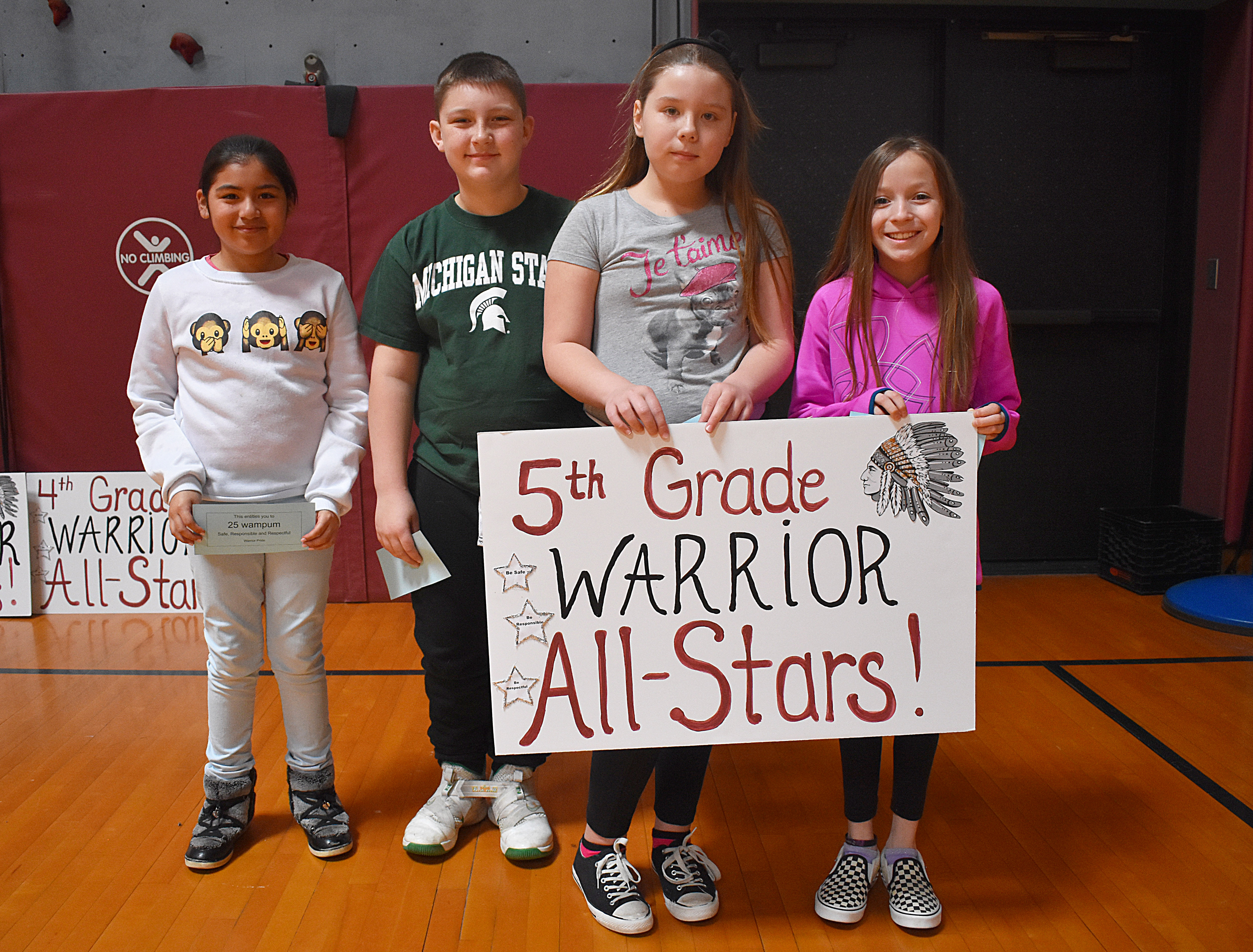 Students standing with fifth grade sign