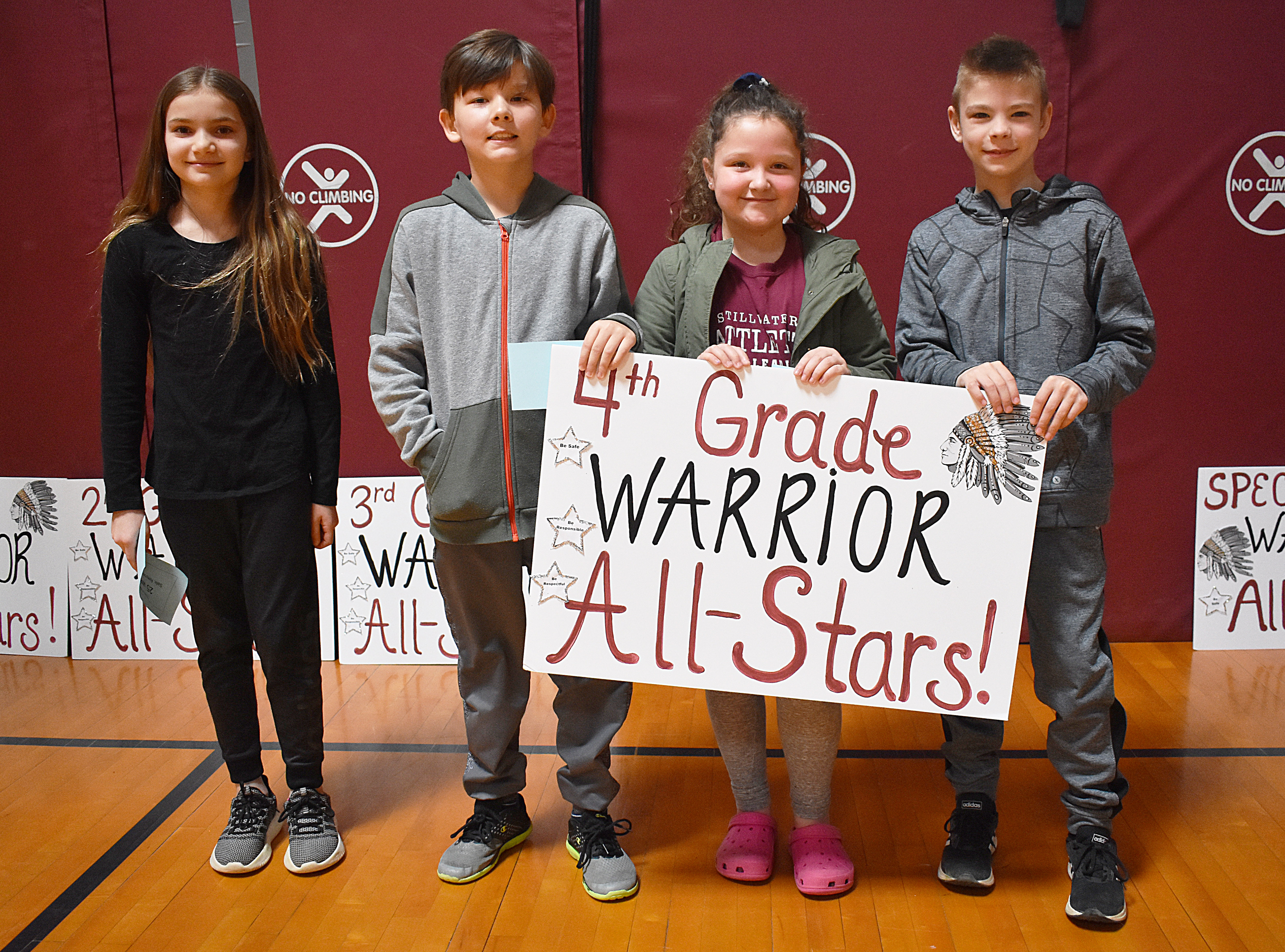 Kids standing together with fourth grade sign