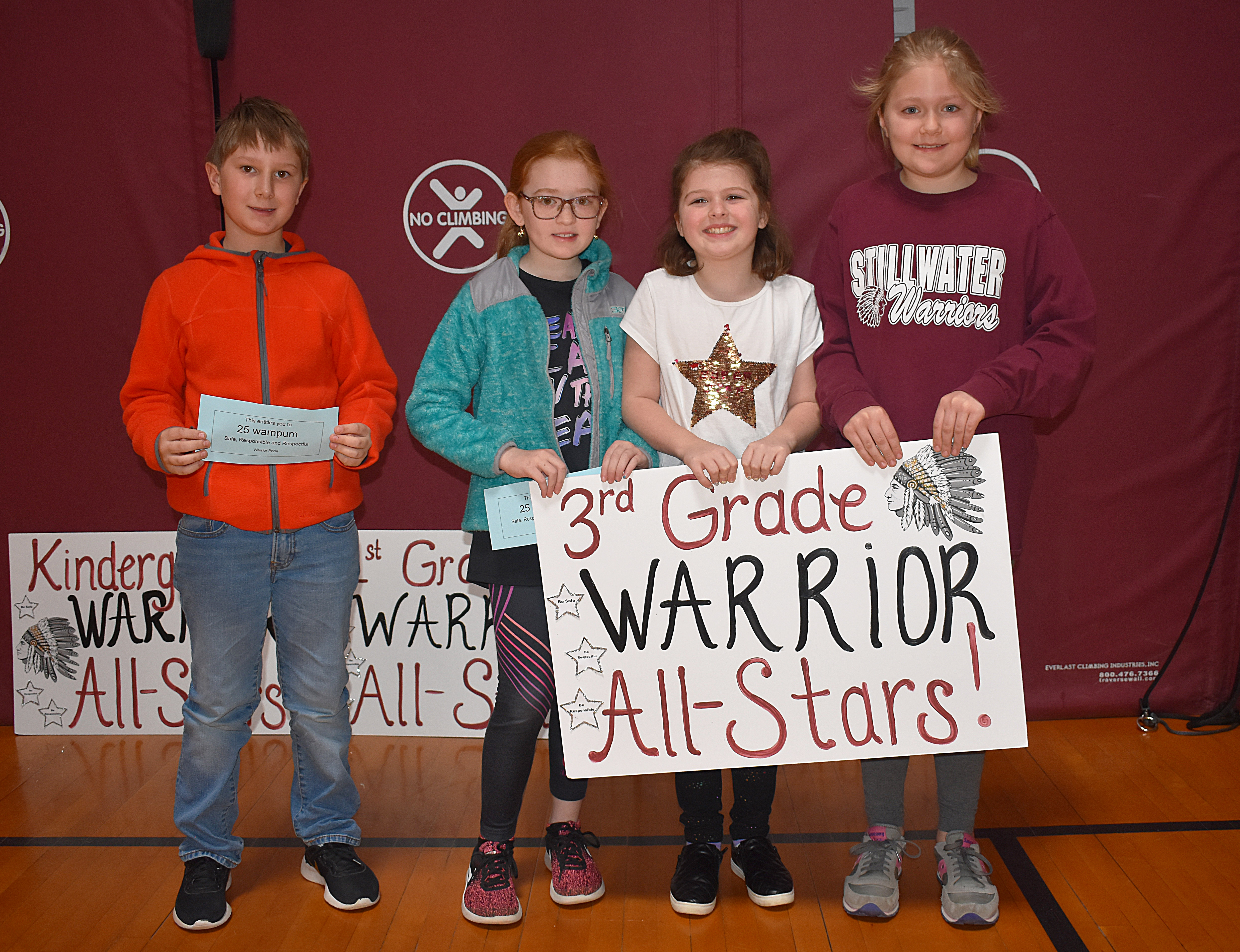 Kids standing together with third grade sign