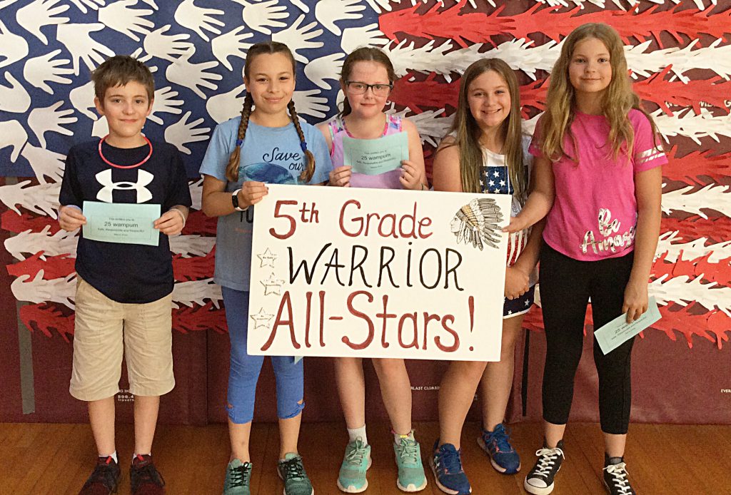 Four girls and a boy with 5th grade sign