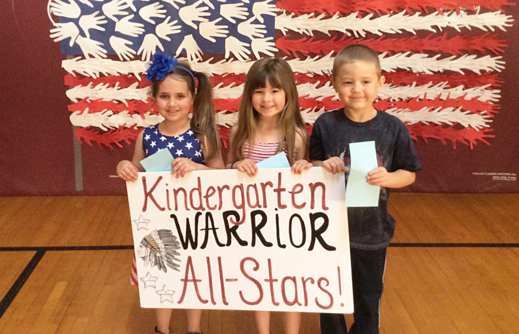 Two girls and a boy with Kindergartern sign