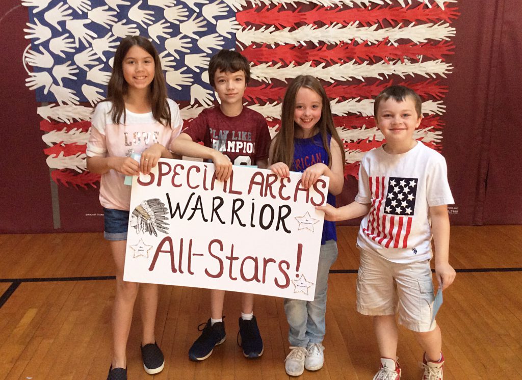 Two girls and two boys with specials sign