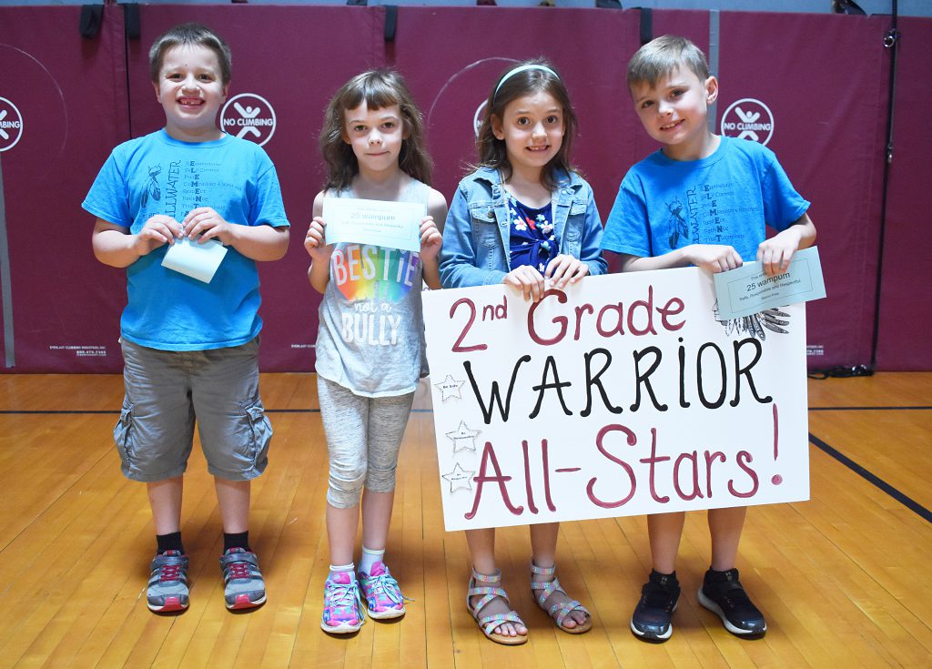 Second graders standing behind sign