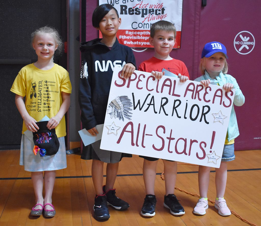 A group of students standing behind specials sign