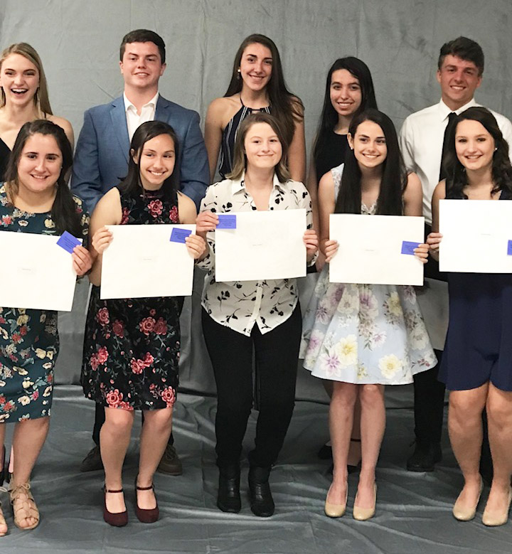 top ten seniors standing in two rows with their certificates