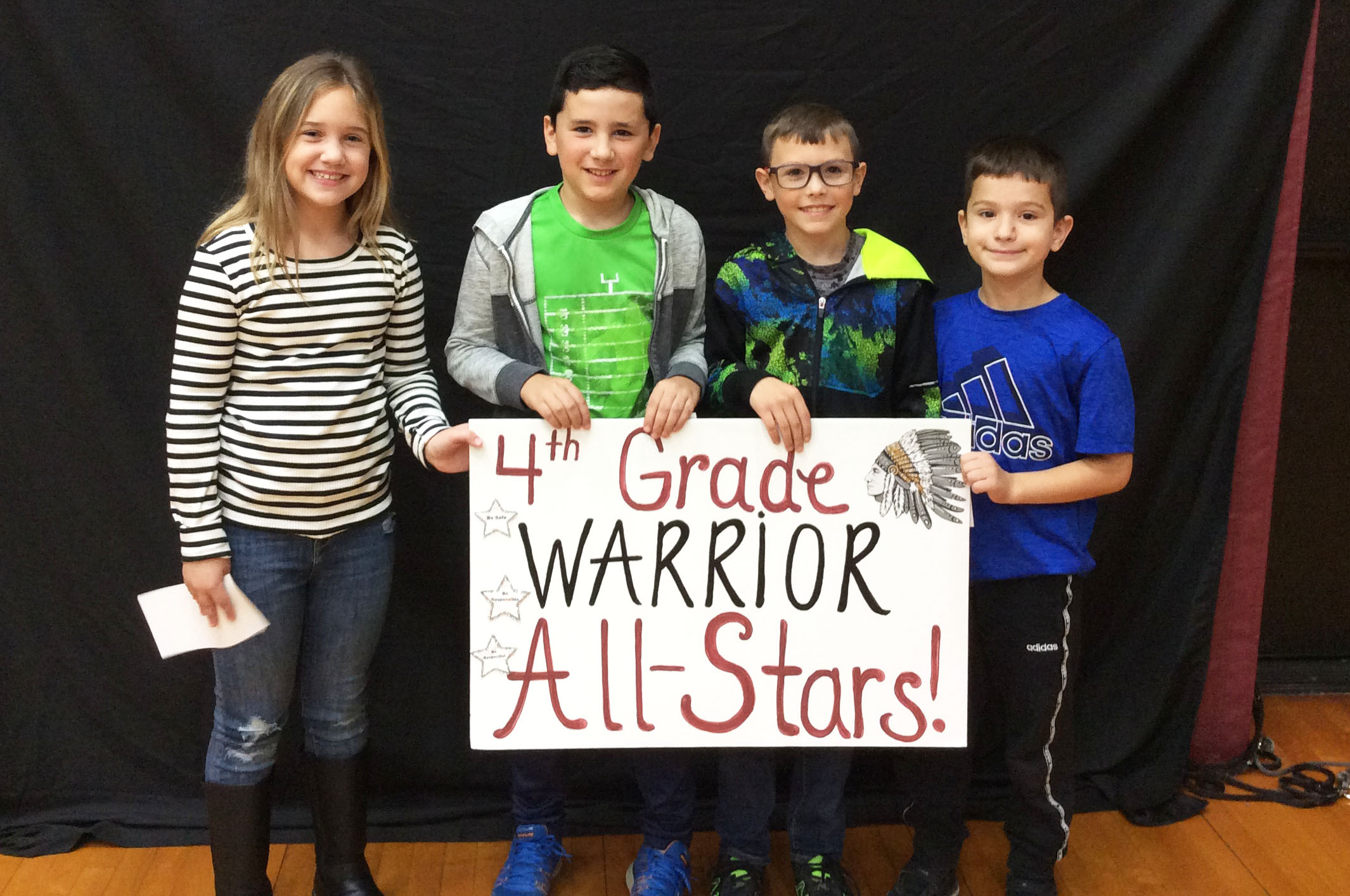 Students standing together with a sign in front of them