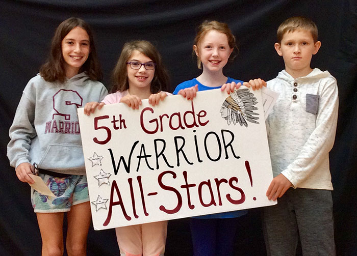 Fifth grade all stars standing with sign