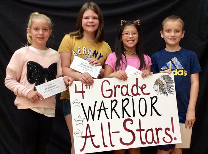 Fourth grade warrior all stars standing with sign