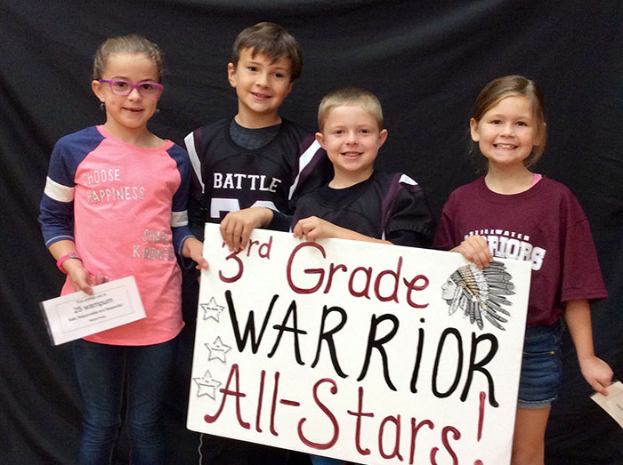 Third grade warrior all stars standing with sign