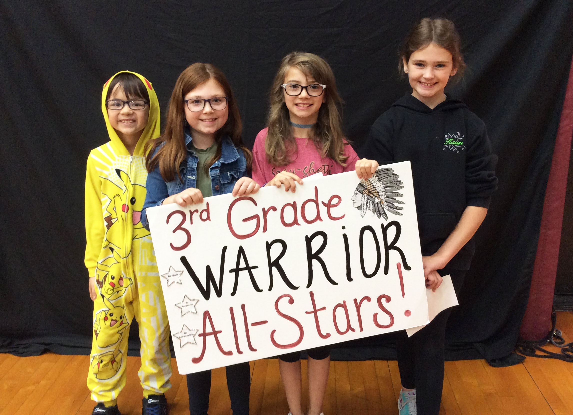 Students standing together with a sign in front of them