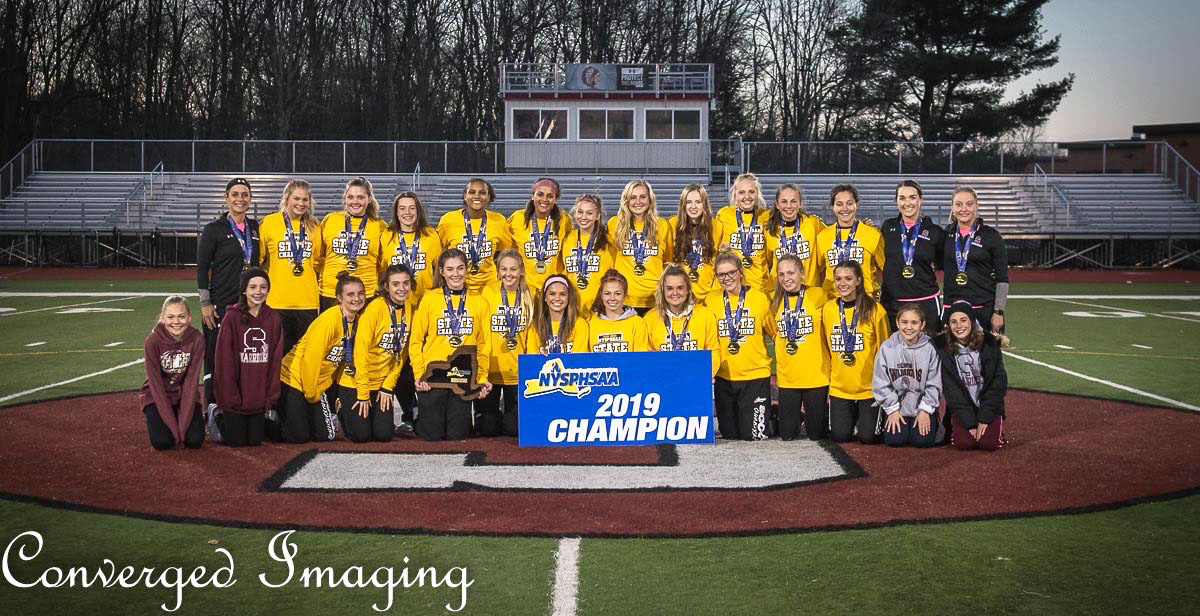 Girls team posed together with state championship banner