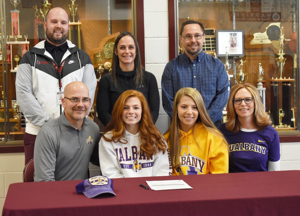 Paige at a table with family and coaches