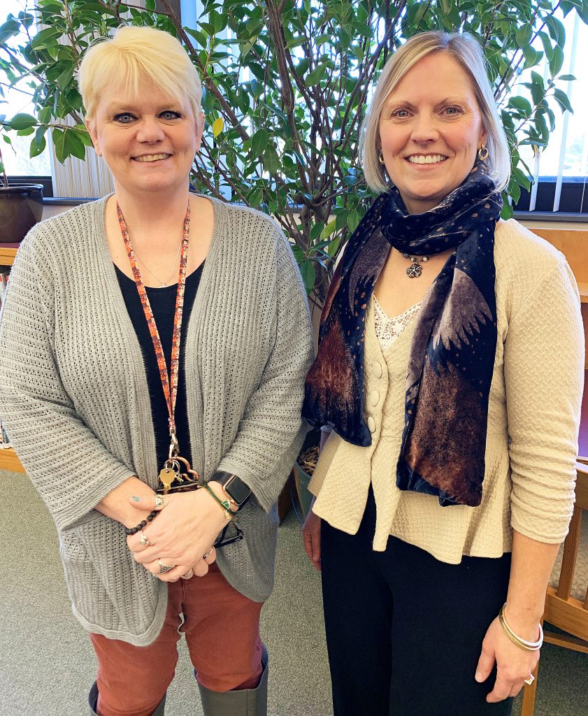 Two teachers standing together, side by side smiling