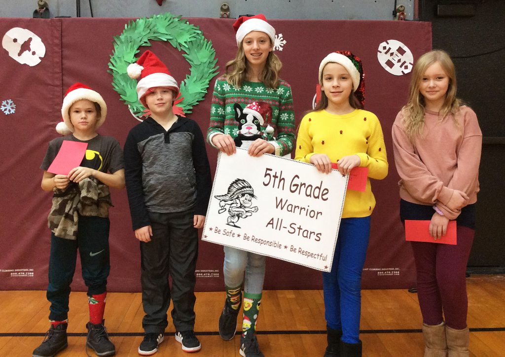 Five fifth grade students standing with warrior sign