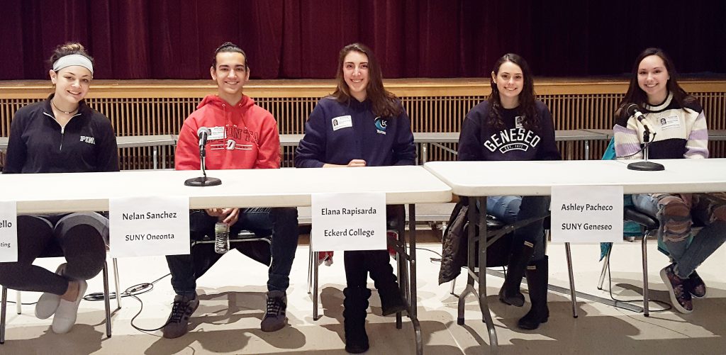Five students sitting at a table with name tags in front of them