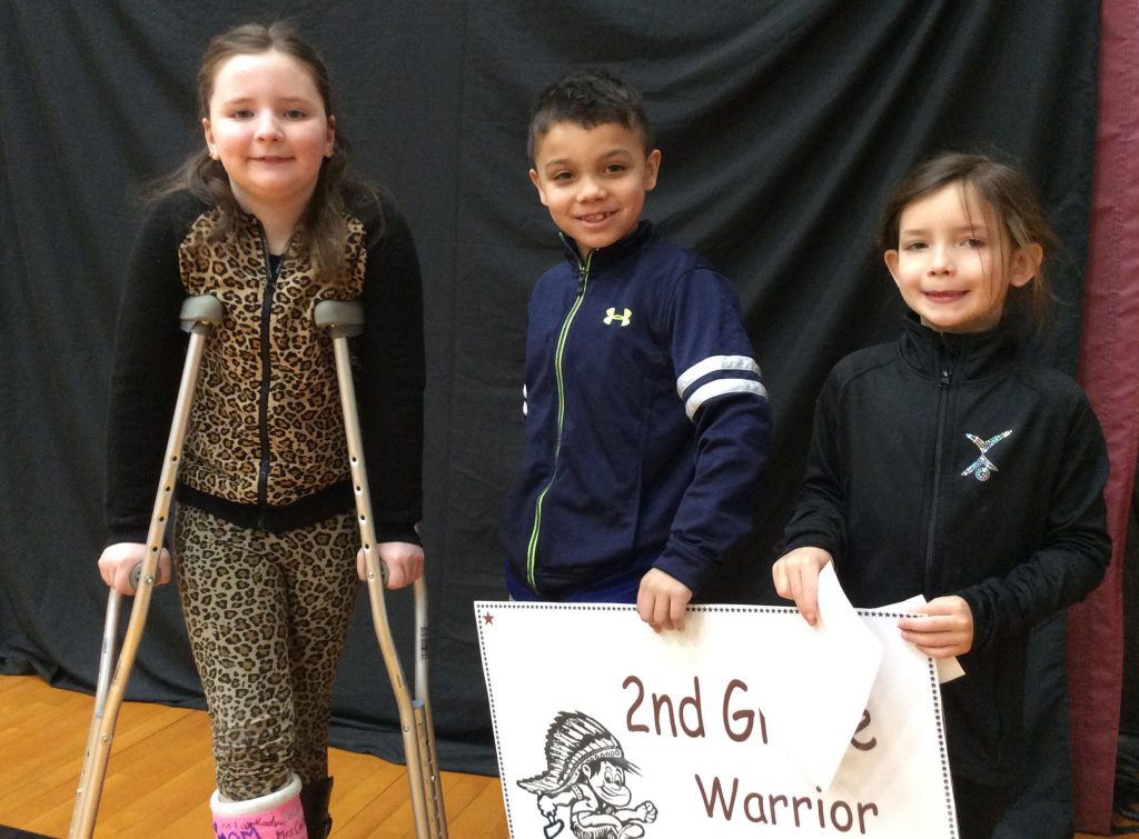 Three second grade students standing with Warrior all star sign