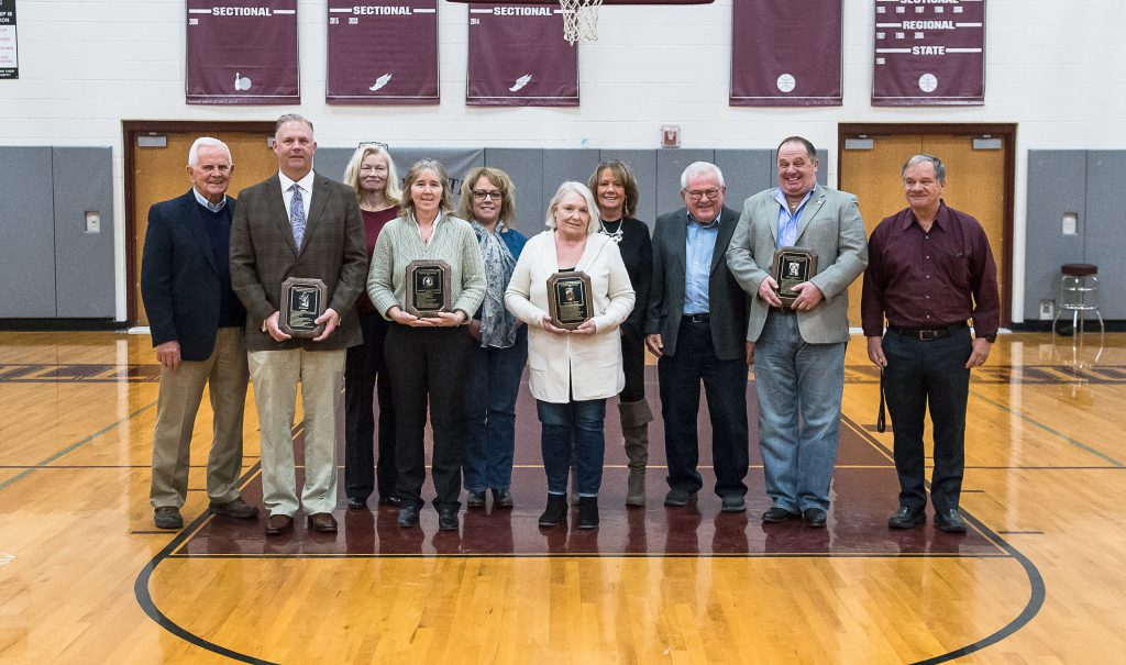 Hall of Fame inductees and their families lined up with their plaques