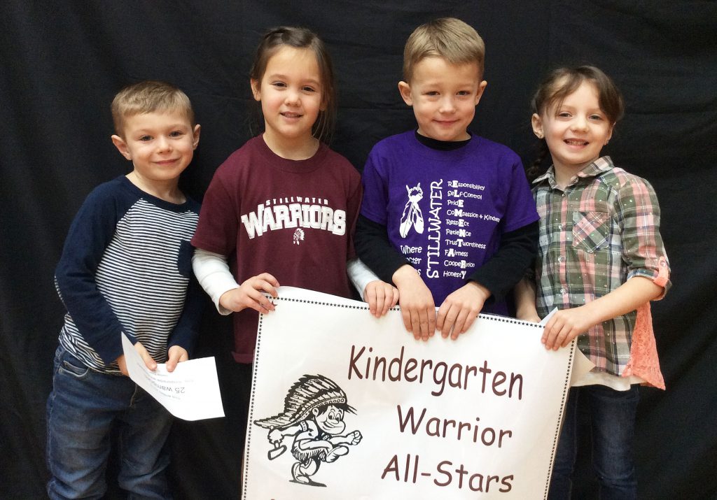 Four kingergarten students standing with Warrior All Star sign