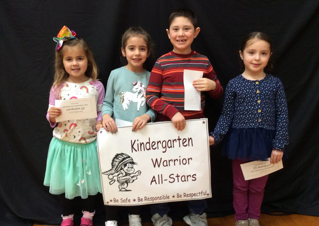 Four students standing with kindergarten warrior all-star sign