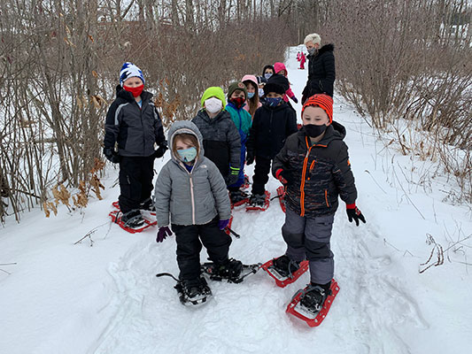 Students snowshoeing with Principal Toleman
