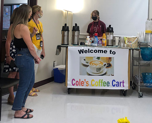 student behind cart serving teachers