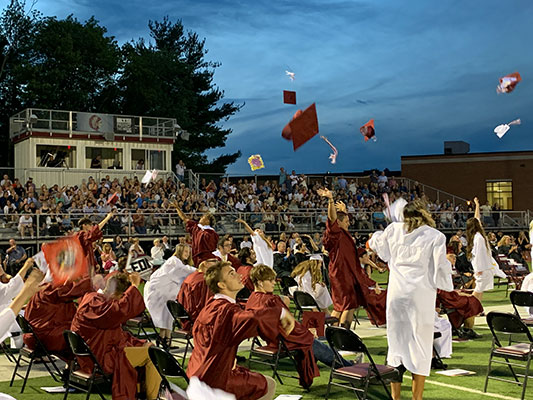 graduates toss their hats