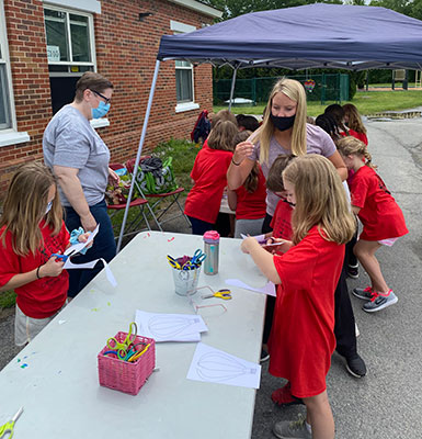 students and staff at an activity table 