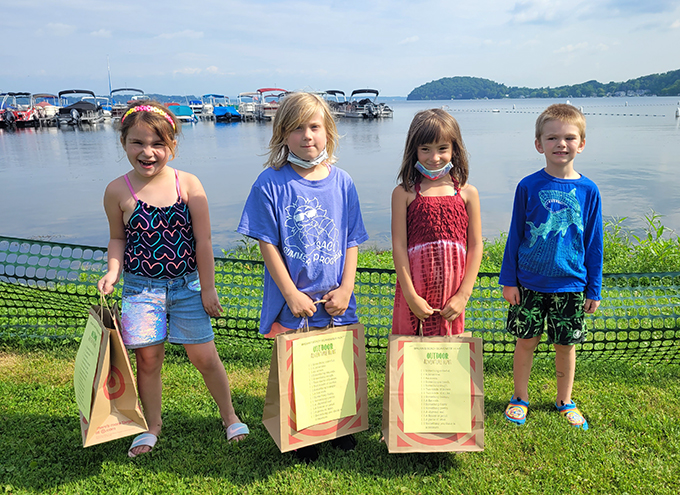 students holding bags in front of lake