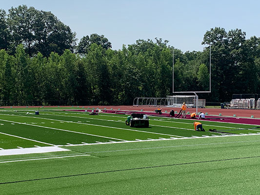 workers installing turf surface