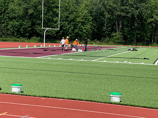 workers installing turf surface