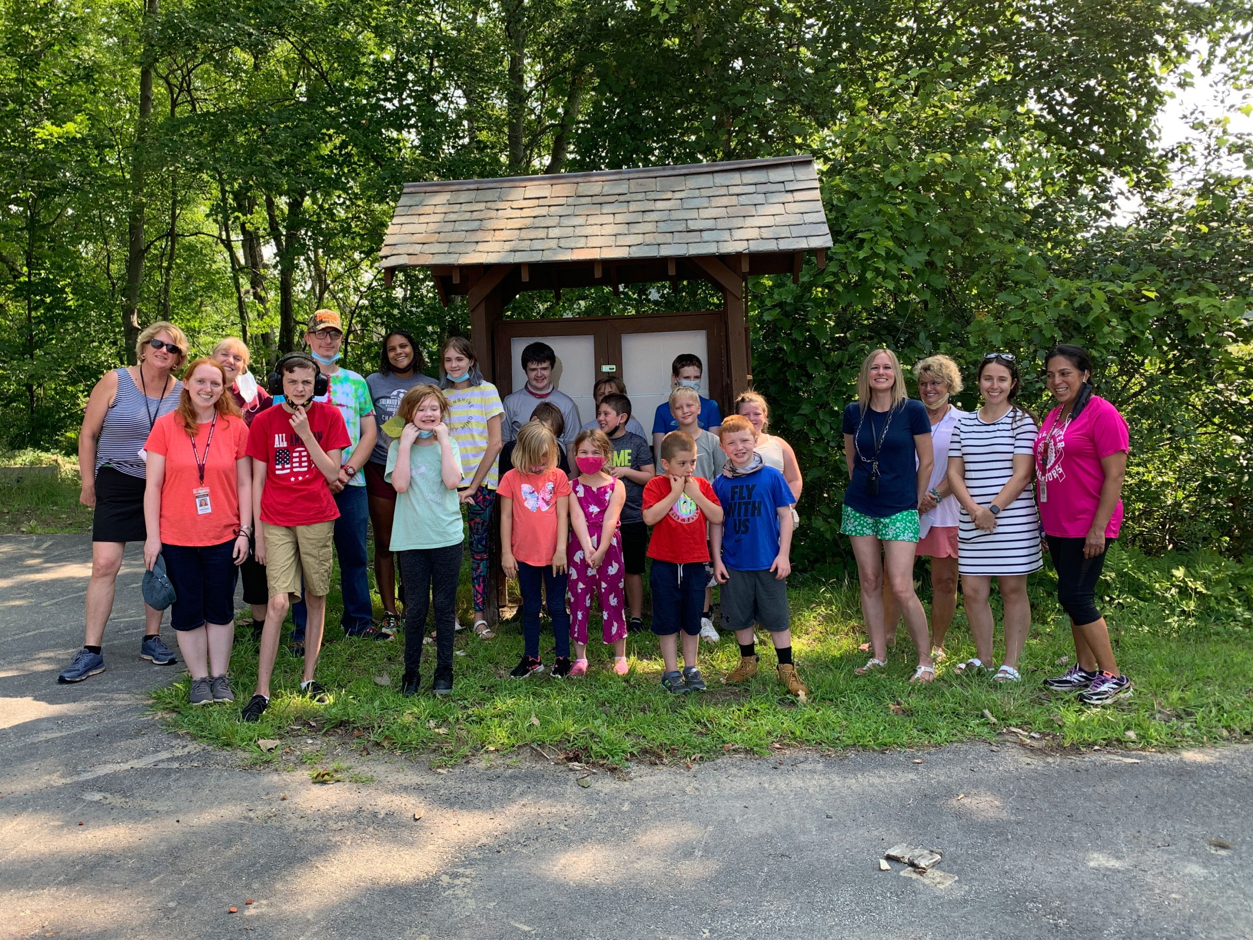 group of students and staff standing by trail sign