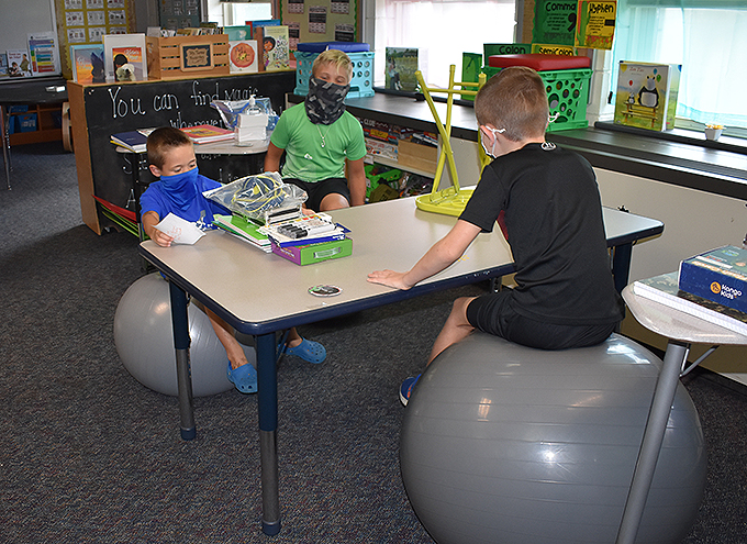 3 students seated on balance balls in their classroom
