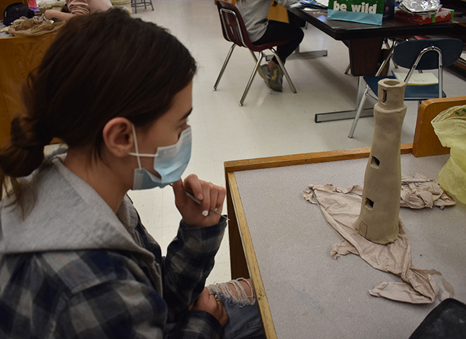 student working on a clay lighthouse