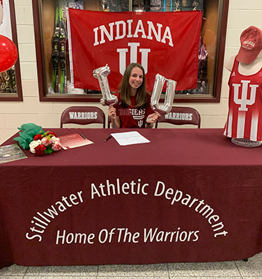 Kelly Moran at the signing ceremony, holding an I and a U balloon