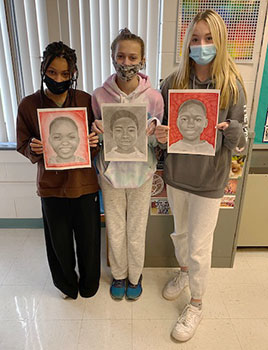 students holding portraits they created